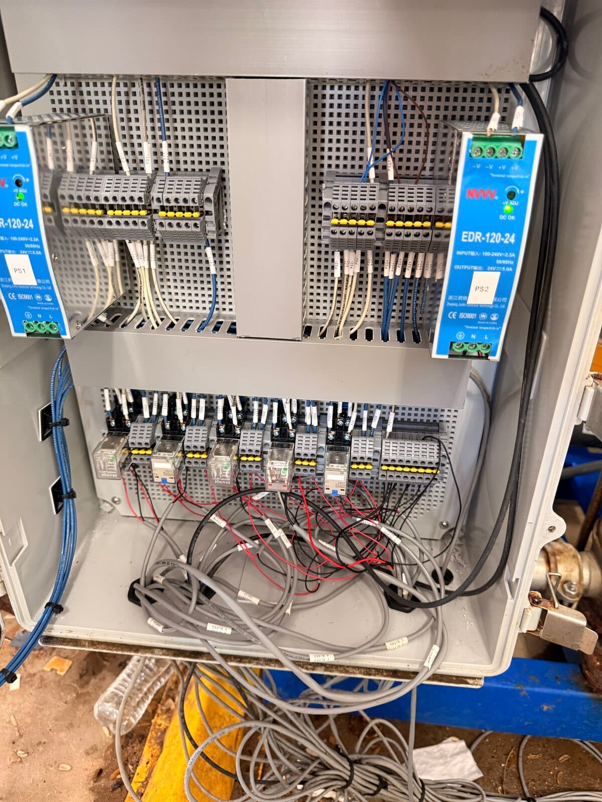 Industrial control panel interior with DIN rail components, relays, and power supply at Falcon Water Tech deployment